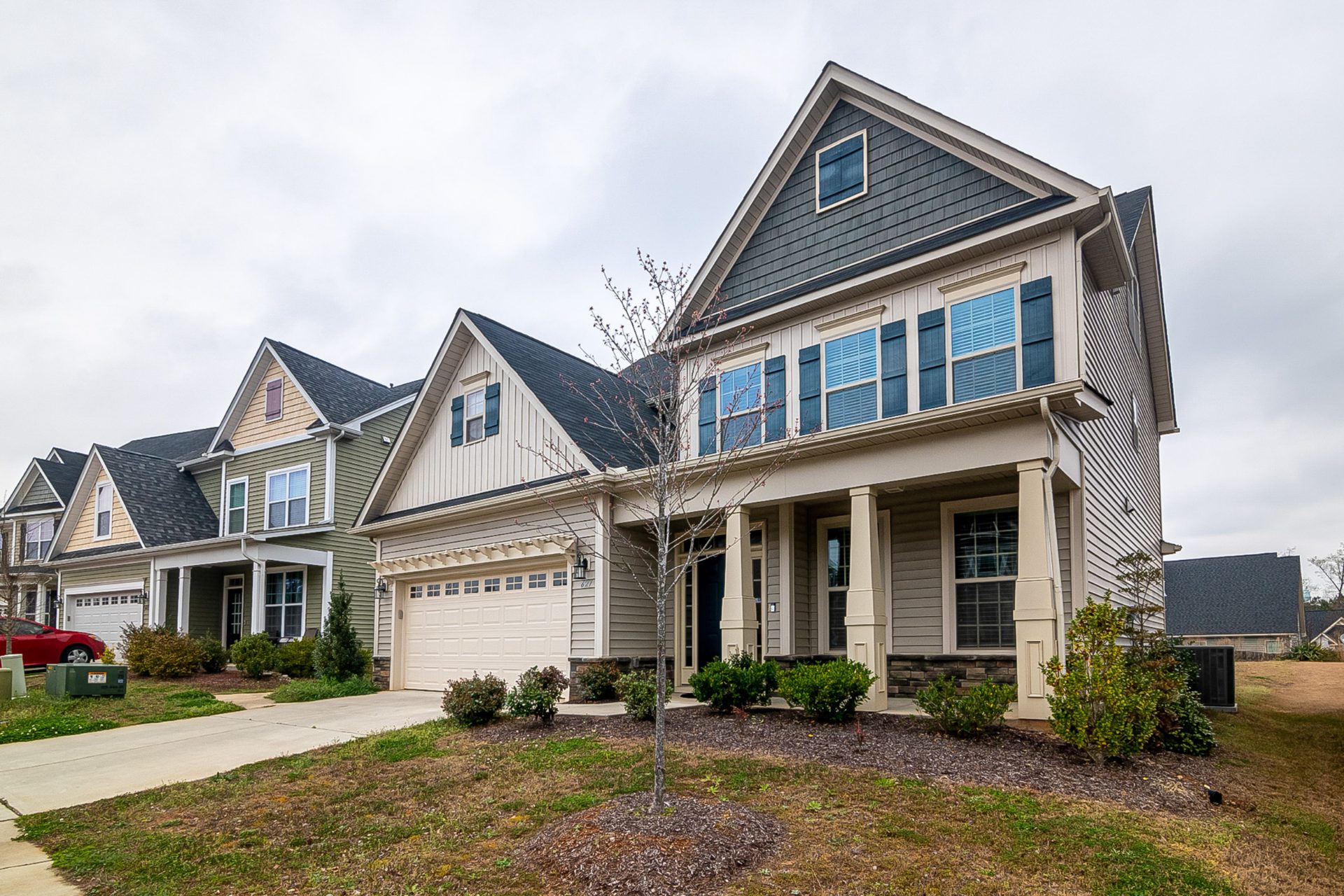 Row of two-story homes with front porches and two-car garages in a newer subdivision