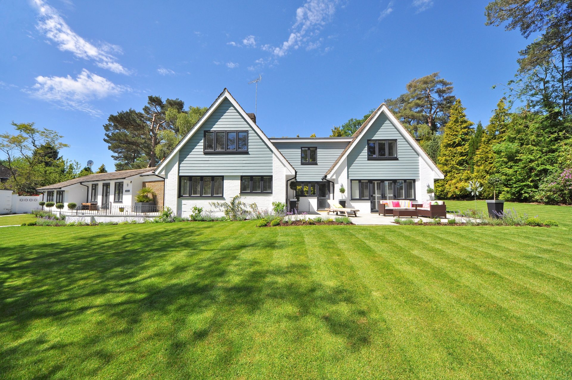 Pale green gabled house behind a wide striped lawn